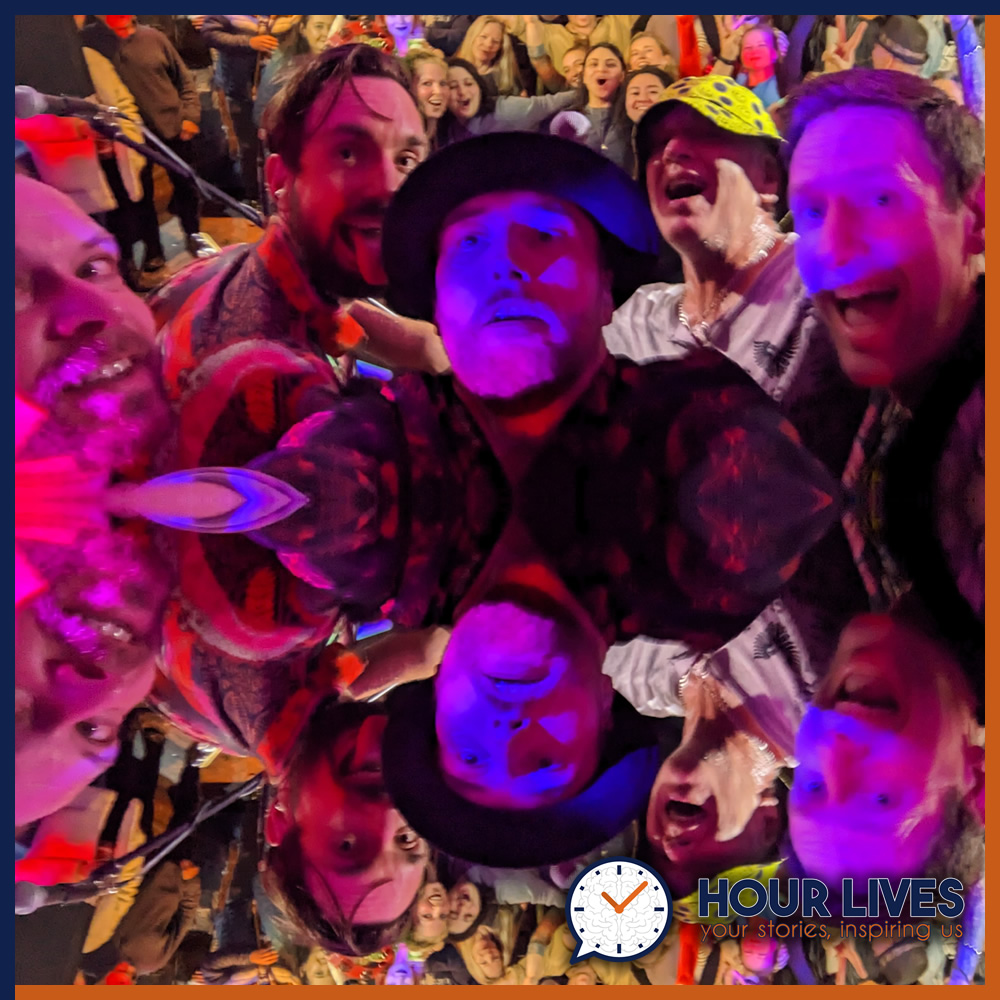 A photo of musicians The Mojo Slide taken as a selfie in front of a live crowd.